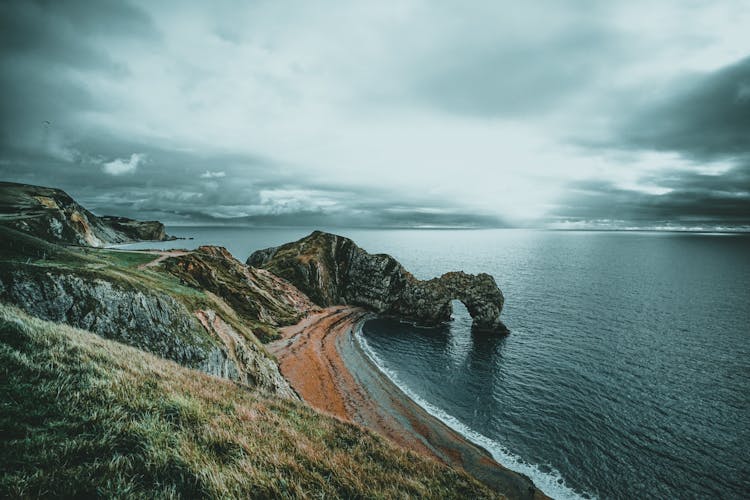 Bay With Orange Seashore Under White And Gray Clouds