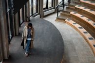 Person Walking on Gray Wooden Stage