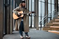 Man in Brown Coat Playing the Guitar