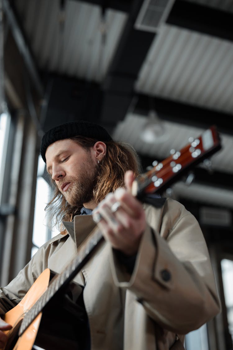 Man Strumming Brown Guitar