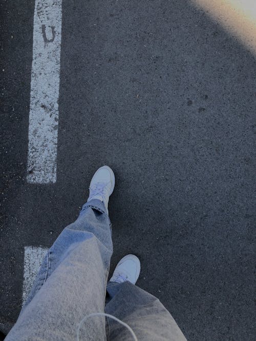 Person Wearing Denim Jeans and White Sneakers