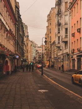 Discover the charm of a narrow urban street lined with historical buildings and vibrant city life.