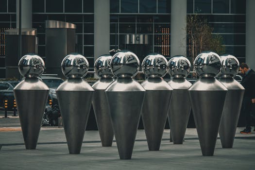 A contemporary metallic sculpture installation in an urban downtown environment, capturing modern artistic expression.