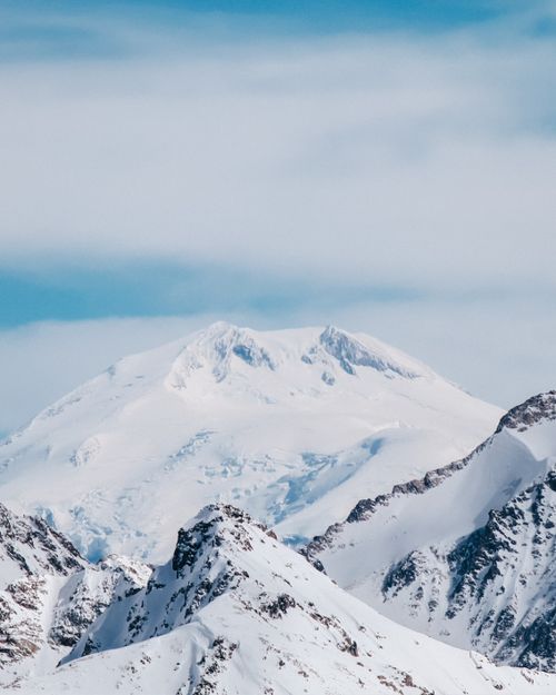 Free Stunning view of snow-covered mountain peaks under a clear sky in winter, showcasing nature's beauty. Stock Photo