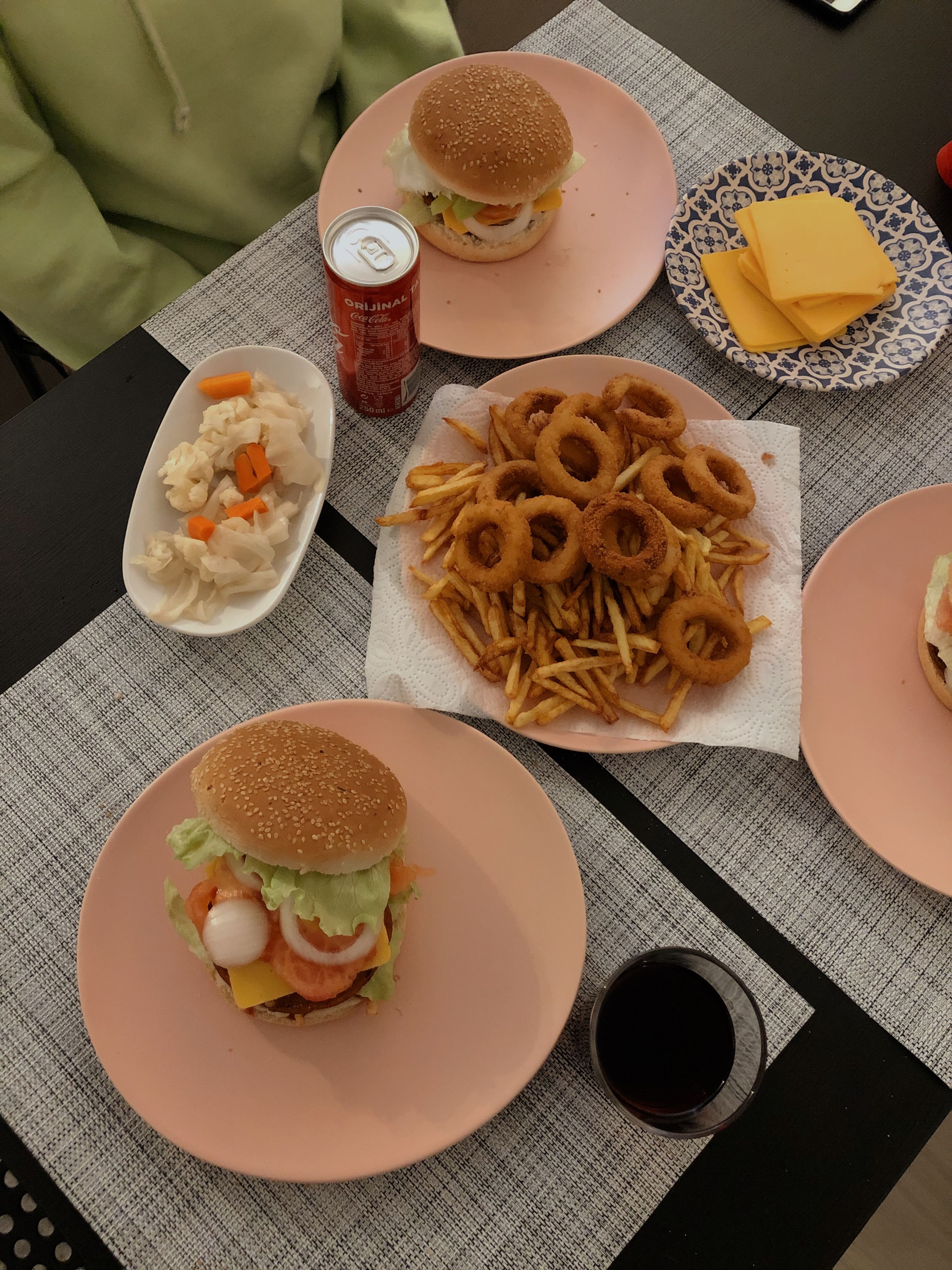 Overhead shot of burgers, fries, and onion rings on a dining table, perfect for a tasty lunch.