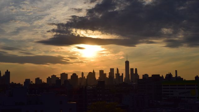 United States, Silhouette of the New York City skyline against a vibrant sunset sky.