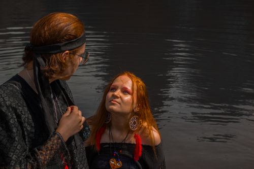 Free A man and woman with bohemian style by the peaceful lake at day. Stock Photo