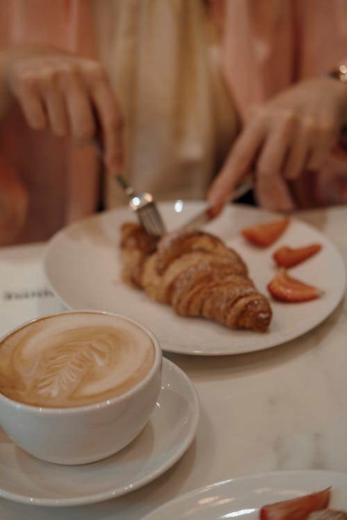 A Person Slicing a Croissant