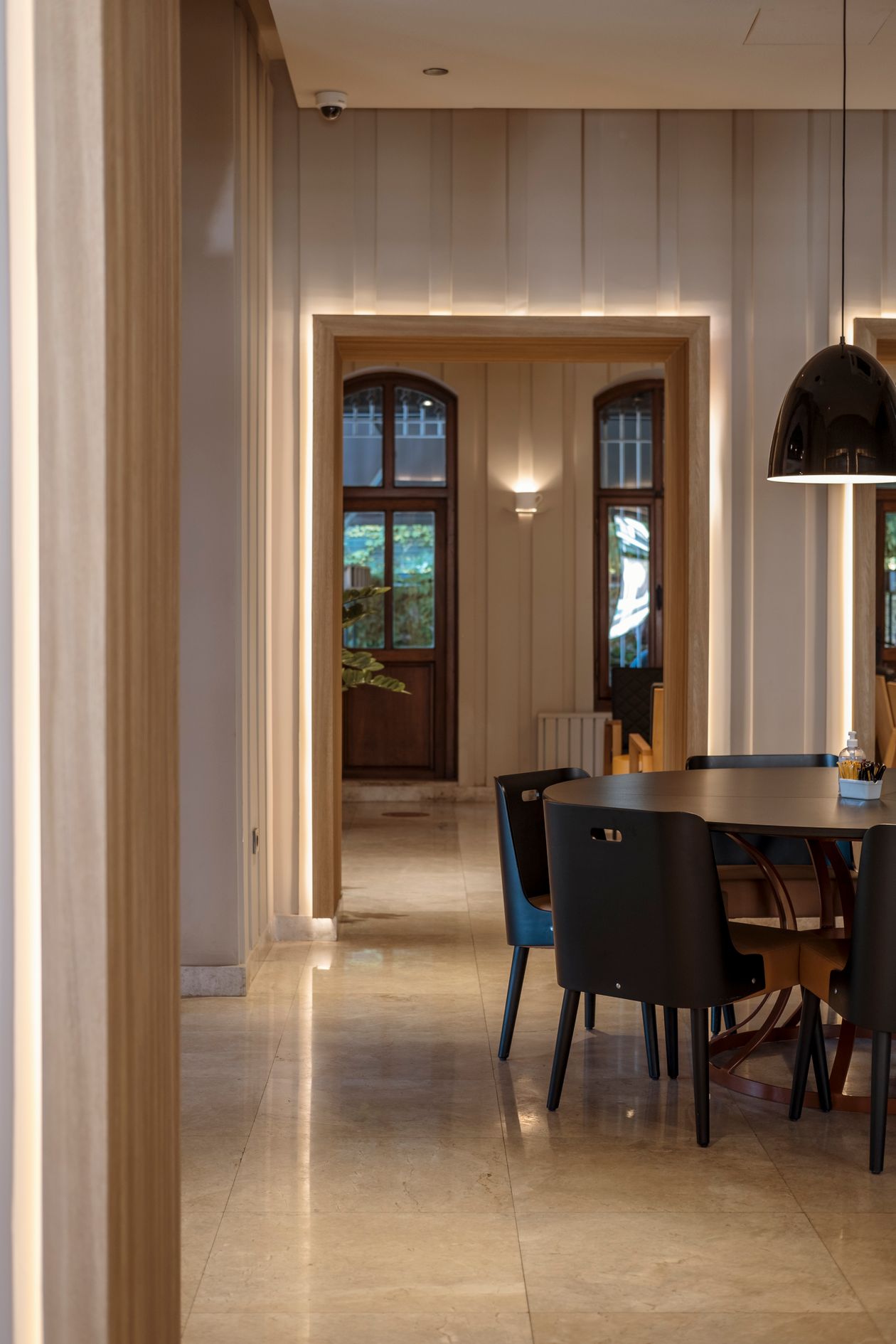 Modern round wooden dining table with four black dining chairs