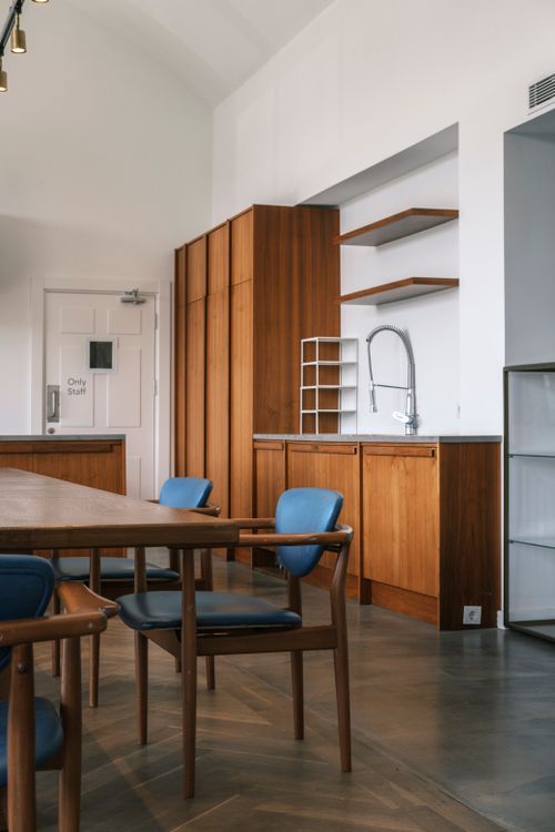 Free Sleek kitchen interior featuring wooden cabinets, blue chairs, and minimalist design. Stock Photo