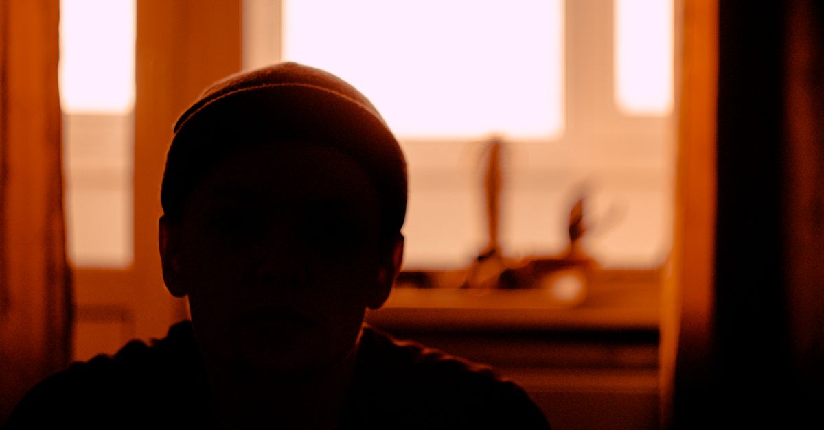 person sitting by window watching sunset with tea, peaceful evening moment