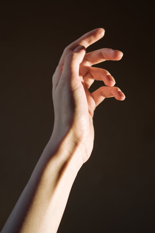 Person's Hand On Black Background