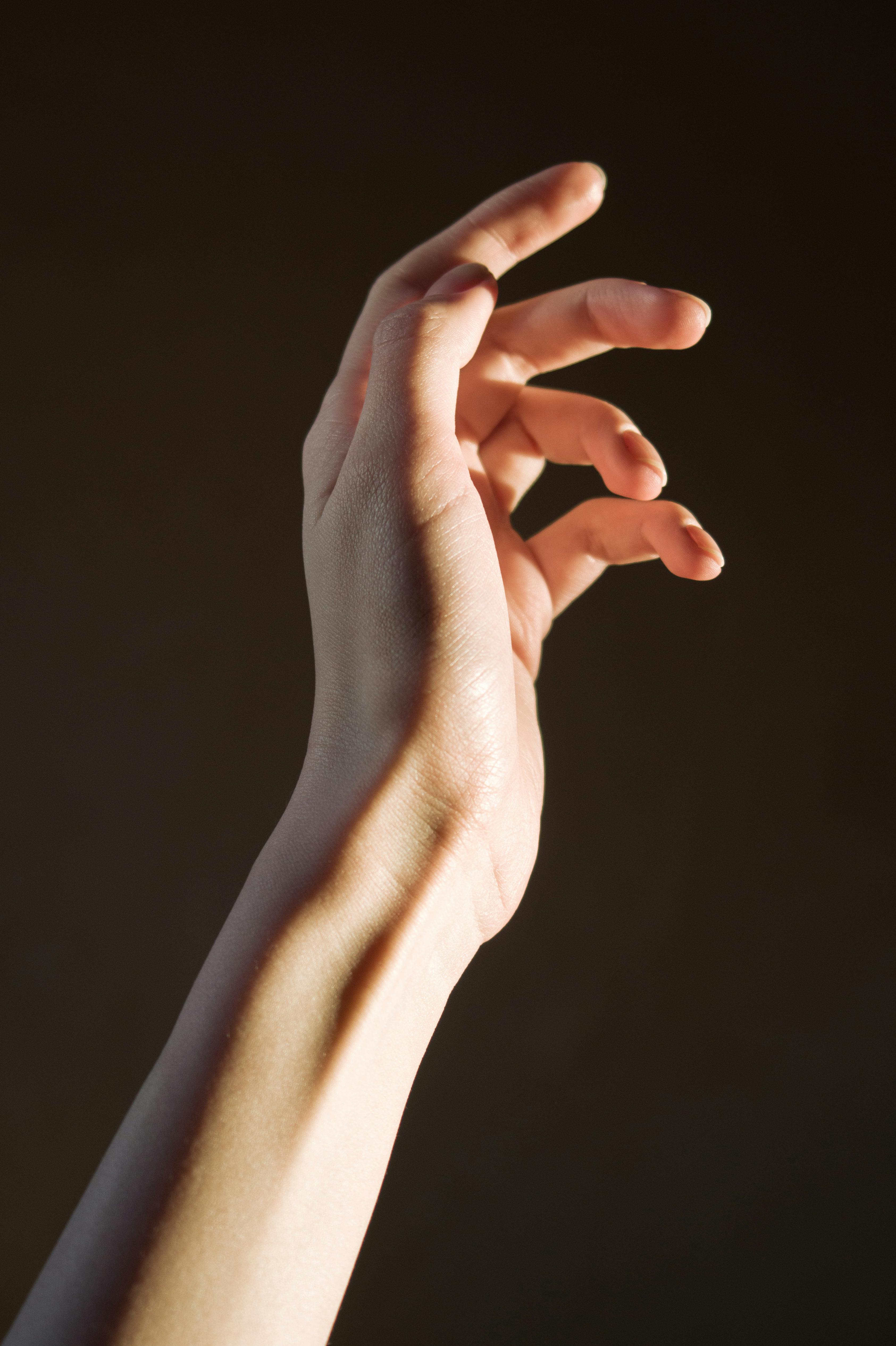 Person's Hand On Black Background · Free Stock Photo
