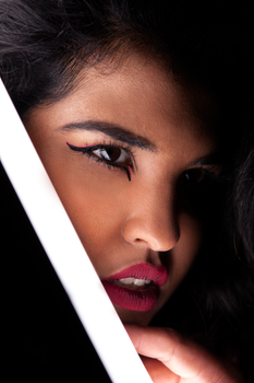 Detailed close-up of a woman with distinctive eye makeup, focusing on her eye and lips.