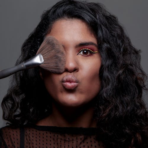 Close Up Photo of Makeup Brush on Woman's Face