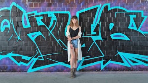 Free A Woman Standing in front of a Graffiti Wall Stock Photo