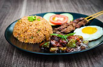 Plate of charred garlic fried rice with a fried egg and skewers, photo by Nazmul Alam Badhon on Pexels