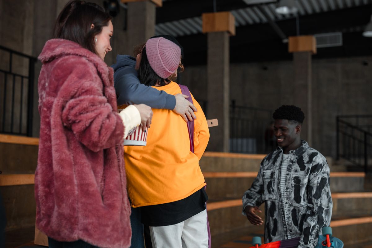 A group of friends hugging each other and smiling