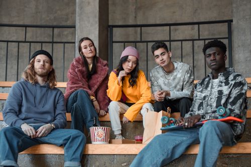 Free A diverse group of fashionable young adults sitting indoors, showcasing modern style and friendship. Stock Photo