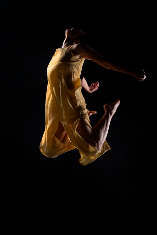 A Woman in Yellow Dress Dancing Gracefully