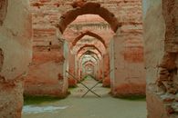 Explore an ancient arched corridor with historical stone walls and a tranquil ambiance.