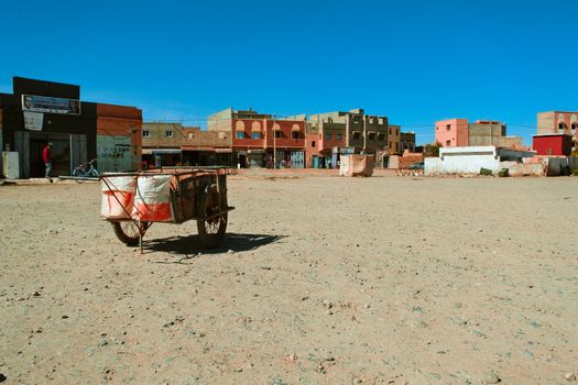 Cart on Two Wheels Between Buildings in a Town 