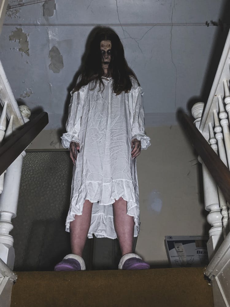 A Creepy Person In White Dress Standing Near The Stairs