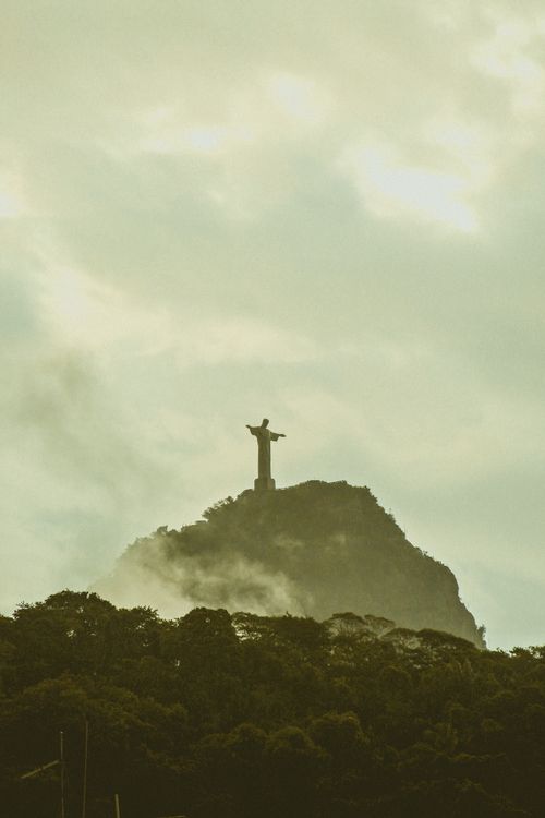 Free Silhouette of Christ the Redeemer statue above misty Rio de Janeiro at sunrise. Stock Photo