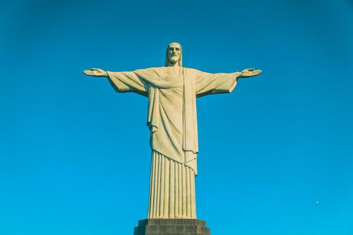 Free Iconic Christ the Redeemer statue set against a clear blue sky in Rio de Janeiro, Brazil. Stock Photo