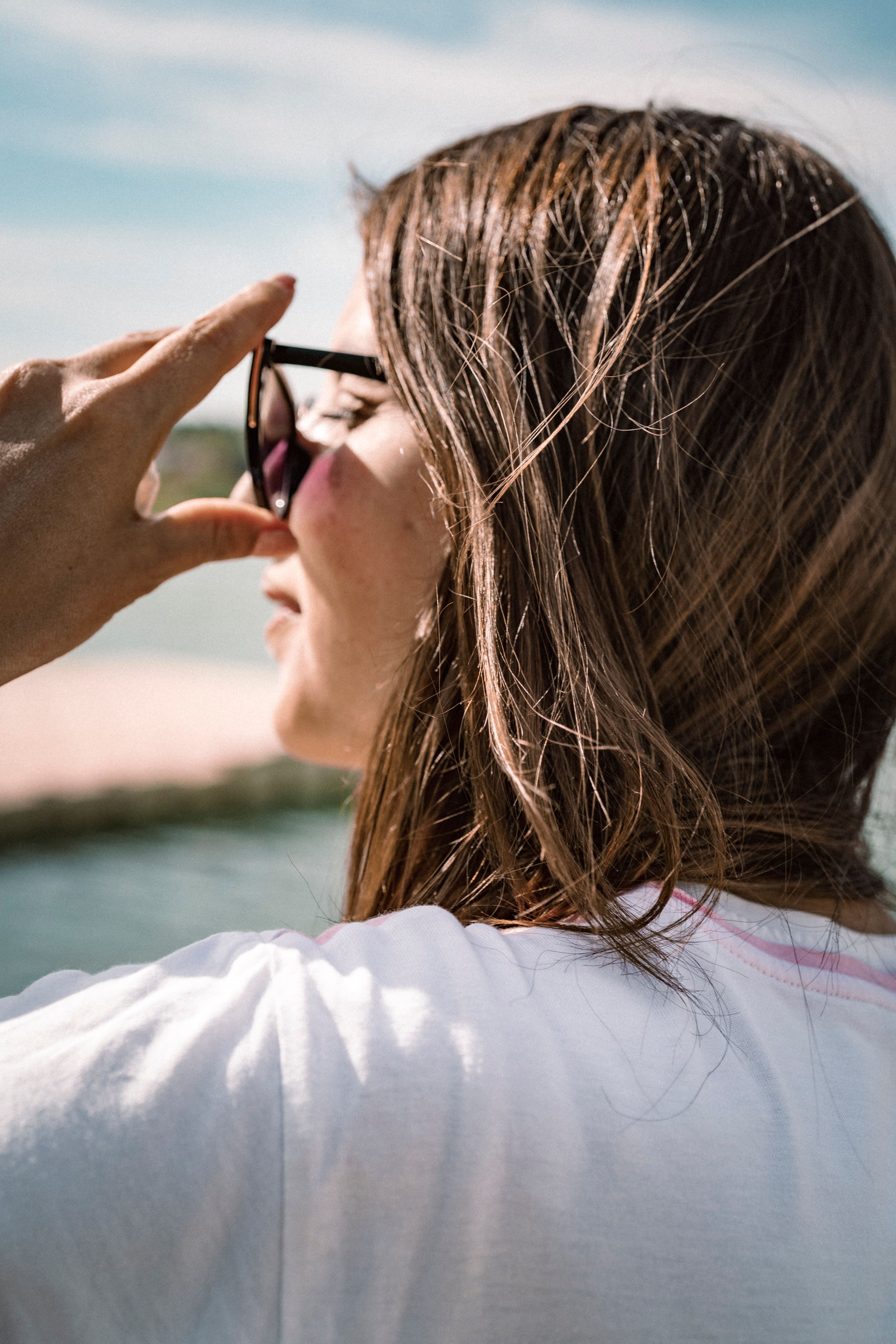 Close-Up Photo of a Woman Touching Her Sunglasses · Free Stock Photo