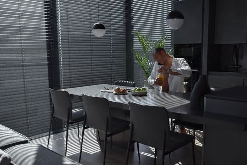 Free A man starts his morning in a modern kitchen, enjoying breakfast with apples and croissants. Stock Photo