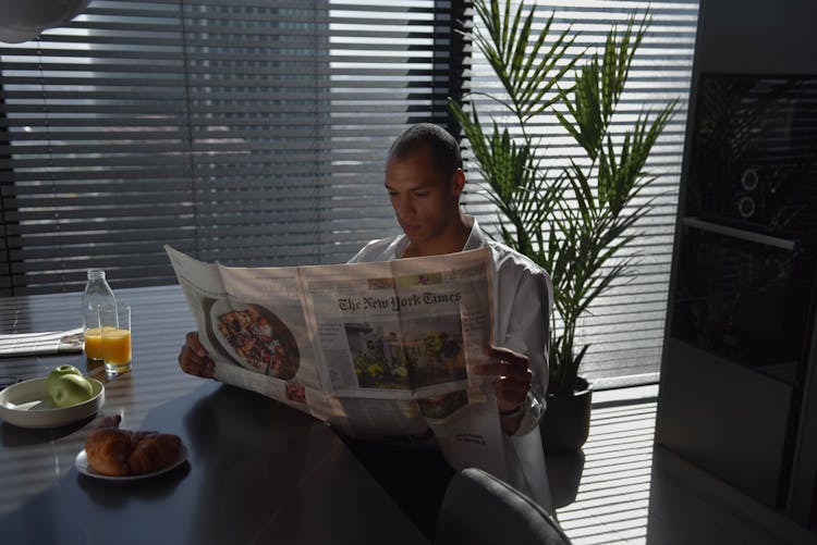 A Man Reading Newspaper At Home