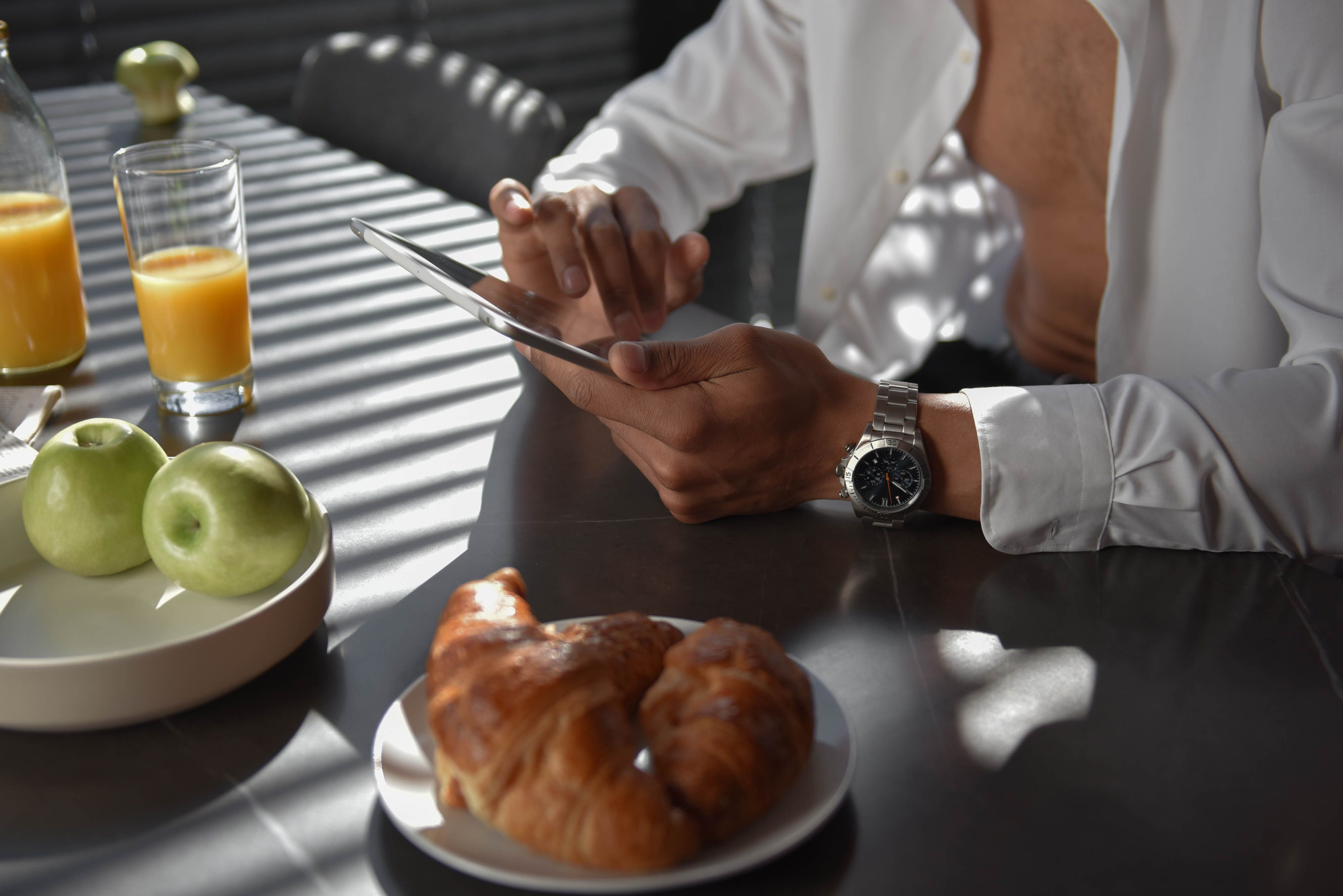 person checking their watch while eating a healthy meal, looking relaxed