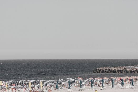 Aerial photo capturing a crowded beachscape with umbrellas and ocean view.