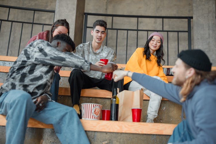 Friends Sitting And Eating And Drinking