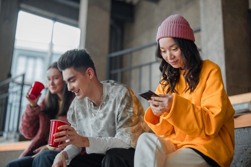 Free Young adults enjoying a casual hangout indoors, capturing moments and sharing laughter. Stock Photo