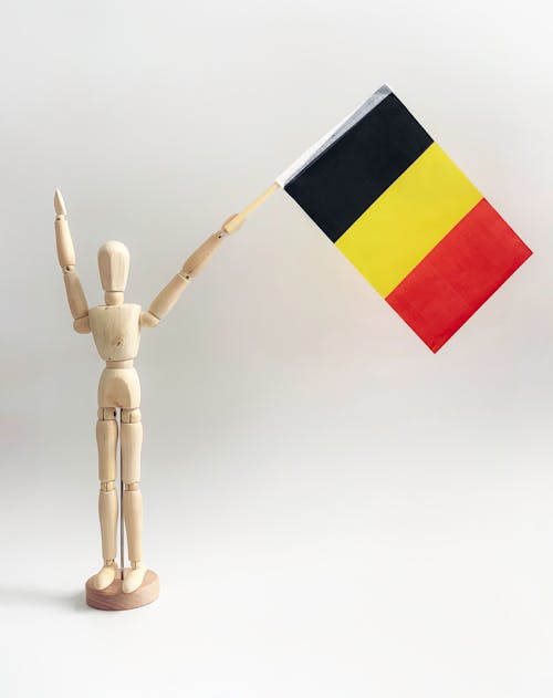 Free A Wooden Dummy Holding a Belgium Flag Stock Photo