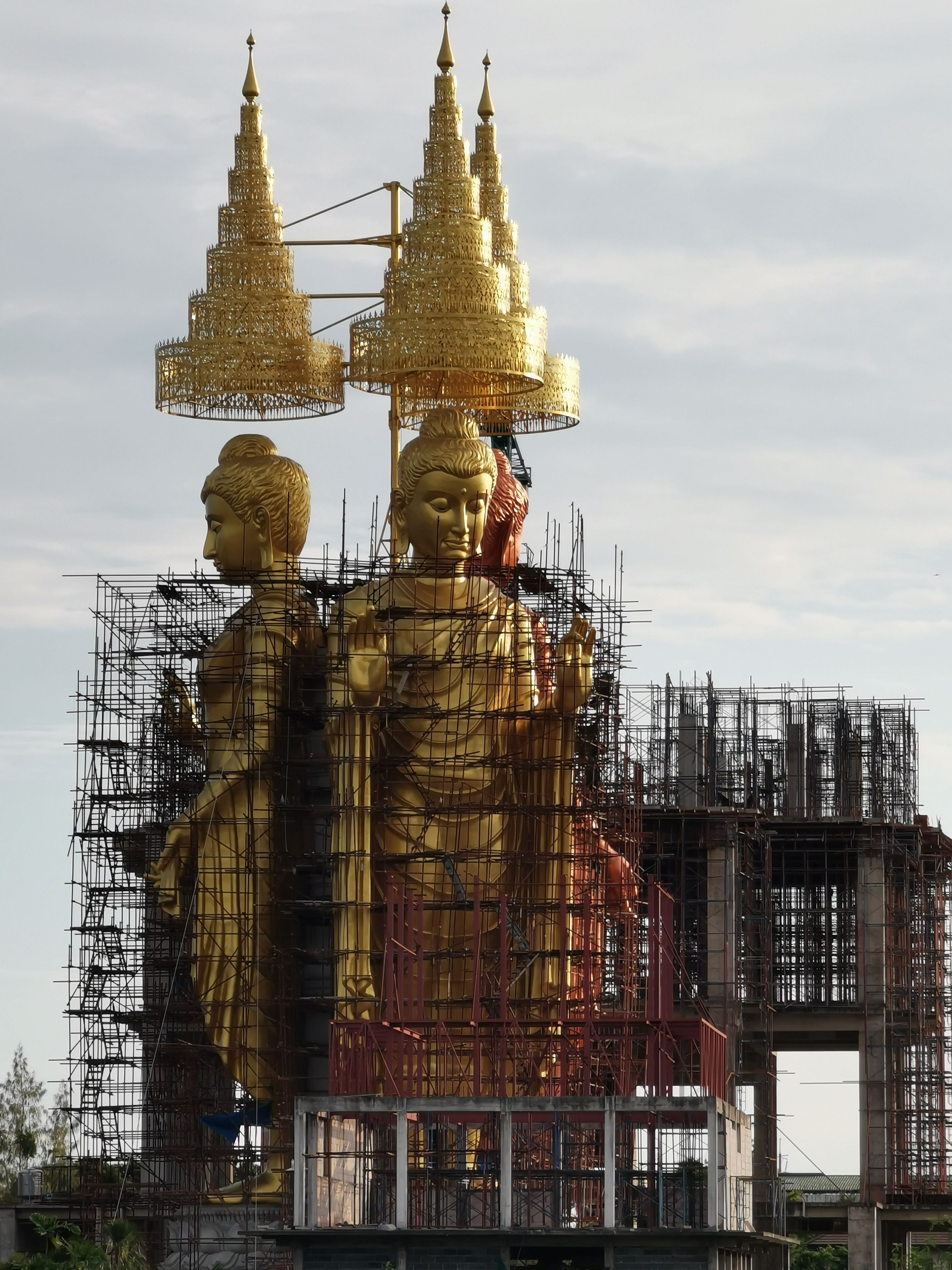 Giant Buddha statues in Wang Daeng, Thailand, under construction, showcasing cultural craftsmanship and spirituality.