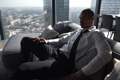 A Man in White Long Sleeves Sitting on the Couch