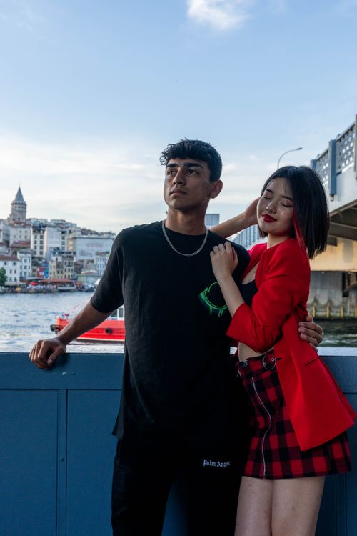 Free Young couple posing by the water in Istanbul with Galata Tower in the background. Stock Photo