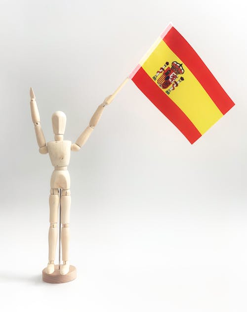 Close-Up Shot of a Wooden Figurine Holding a Flag