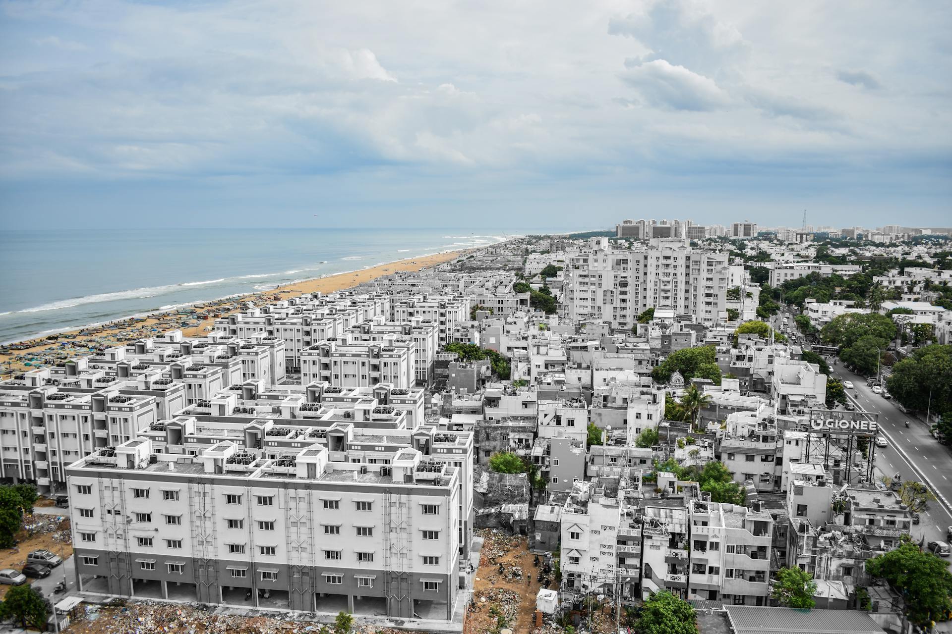 Aerial view of Chennai's urban landscape with Marina Beach in the background.