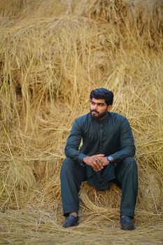 Man in Black Jacket Sitting on Brown Grass Field