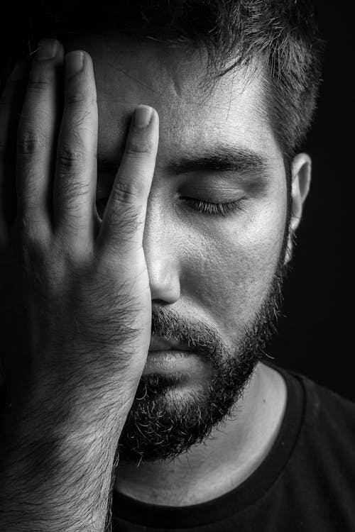 Grayscale Photo of Man Covering Half His Face