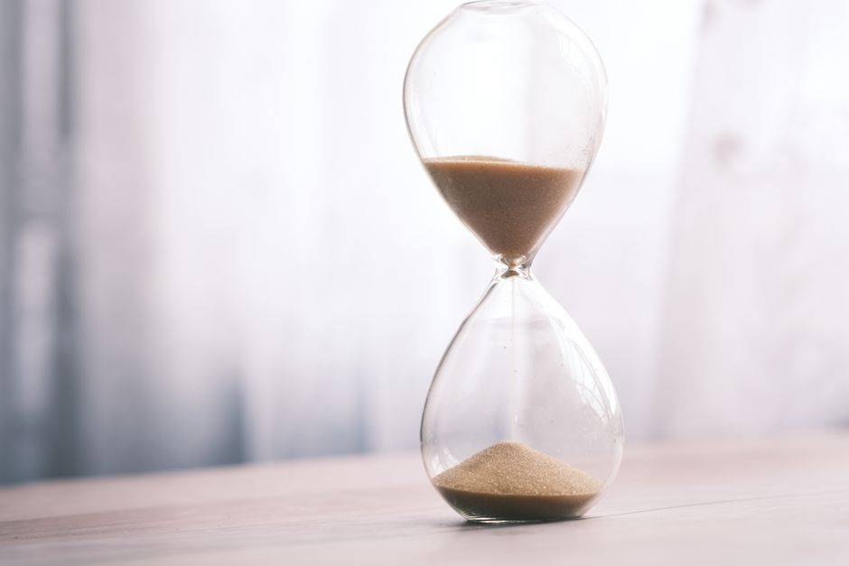 Hourglass with flowing sand — ibogaine lasts 12–24 hours; 5-MeO-DMT lasts 20–45 minutes, but intensity within that window is often described as total