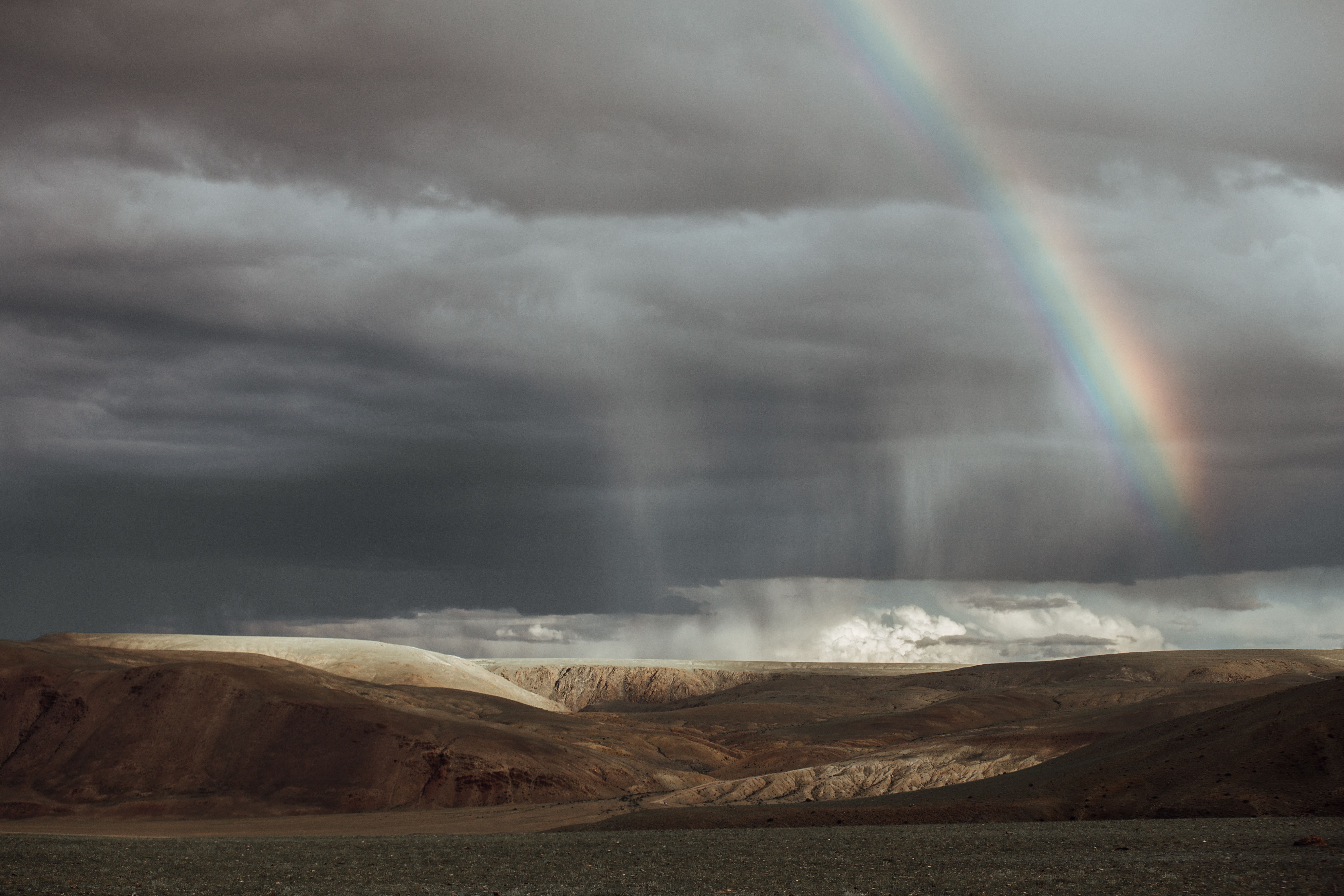 Rainbow in the Gray Sky Above Mountains and Sea · Free Stock Photo