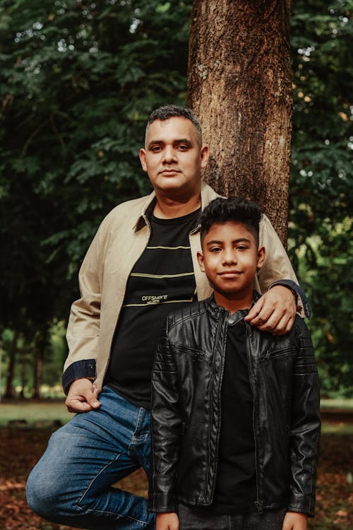 Father and Smiling Son Beside Tree