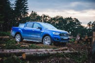 Blue Pickup Truck on the Road Among Timber