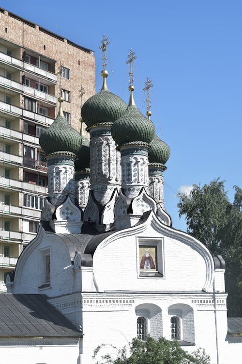 Free White Brick Uspenskaya Church Beside Apartment Building in Nizhny Novgorod, Russia Stock Photo
