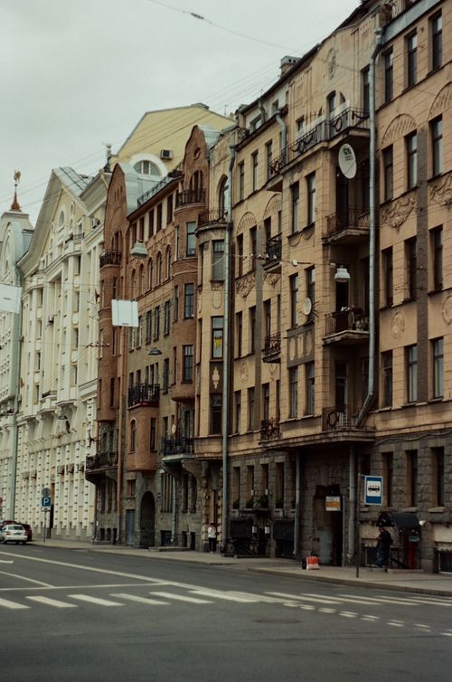 Free A picturesque view of a narrow urban street lined with vintage architecture, capturing the city's old-world charm. Stock Photo